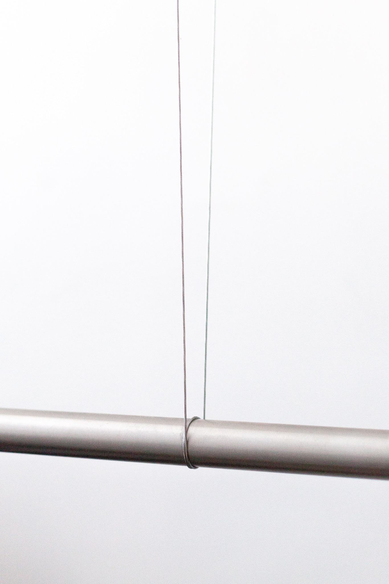 Detalle del cable y la barra del perchero suspendido